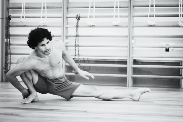 男性がピラティスを行う前のストレッチを行う様子