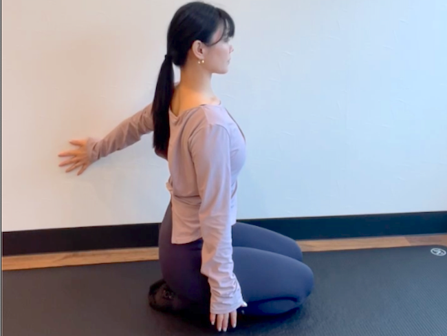 壁を用いたウォールピラティスを行う女性