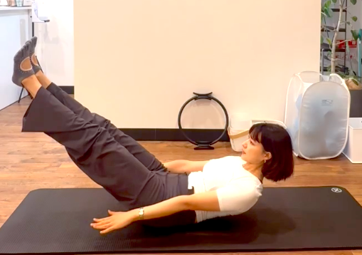 ピラティスの「ハンドレッド」を行う女性